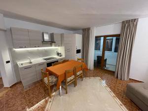 Una cocina y un comedor con mesa y sillas. en Izvor apartament, en Borsa