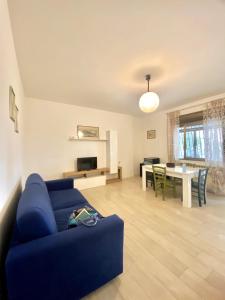 a living room with a blue couch and a table at DolceMare - Apartment in Lido di Jesolo