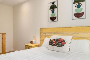 a bedroom with a white bed with a flower pillow on it at NEW! Charming Palmela Retreat near Arrábida&Castle in Palmela