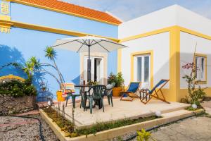 a patio with a table and chairs and an umbrella at NEW! Charming Palmela Retreat near Arrábida&Castle in Palmela