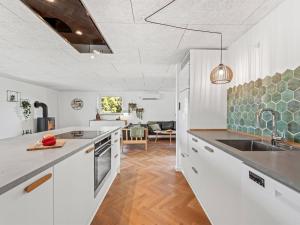 a kitchen with white cabinets and a sink at Holiday Home Bela - from the sea by Interhome in Ringkøbing