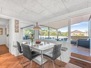 a dining room with a white table and chairs at Holiday Home Bela - from the sea by Interhome in Ringkøbing