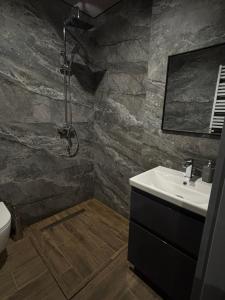 a bathroom with a sink and a shower at ChillVille in Ternopilʼ