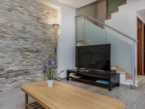 a living room with a television and a brick wall at Holiday Home Sol Cambrils Park 28 by Interhome in Cambrils +38 photos