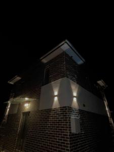 un alto edificio di mattoni con luci accese di notte di ChillVille a Ternopilʼ