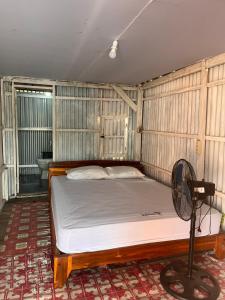 ein Bett in einem Zimmer mit Ventilator in der Unterkunft Hill House Rammang-Rammang in Kasijala