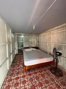 Zimmer mit einem Bett und einem Ventilator in der Unterkunft Hill House Rammang-Rammang in Kasijala