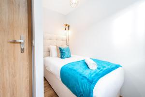 ein Schlafzimmer mit einem Bett mit einer blauen Decke darauf in der Unterkunft Stylish 2 Bed Apartment - Easy Access to Stourbridge - Free Parking - Fast Wi-Fi 1AS in Amblecote + 28 Fotos