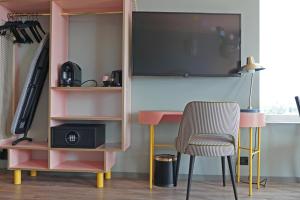 a desk with a tv and a chair in a room at Best Western Plus Åby Hotel in Mölndal