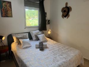 una camera da letto con un letto con cuscini e una finestra di Kay lanmou location de vacances Sainte Anne a Sainte-Anne Altre 16 foto
