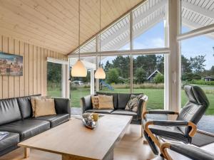 a living room with a couch and chairs and a table at Holiday Home Dorde - 600m from the sea by Interhome in Rødby +20 photos