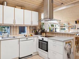 una cucina con mobili bianchi e un lavandino di Holiday Home Tyyne - 250m from the sea by Interhome a Tjørneholm