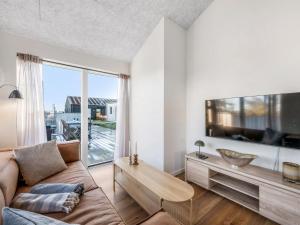 a living room with a couch and a large window at Apartment Kjeld - from the sea by Interhome in Ringkøbing