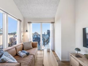 a living room with a couch and a large window at Apartment Kjeld - from the sea by Interhome in Ringkøbing +18 photos