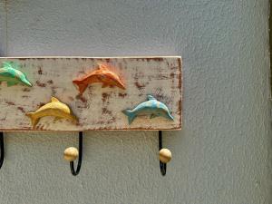a painting of four fish on a wall at Mar de Corais Hospedagem in Serra