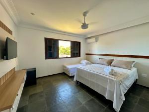 a bedroom with two beds and a window at Mar de Corais Hospedagem in Serra +3 photos