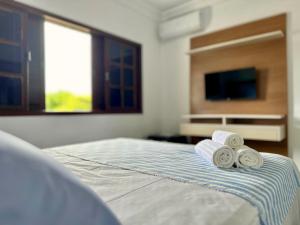 a bedroom with a bed with two rolled towels at Pousada Mar de Corais in Serra +3 photos