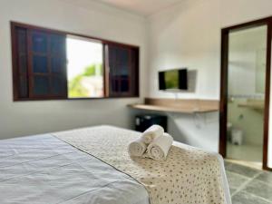 a bedroom with two rolled towels on a bed at Pousada Mar de Corais in Serra