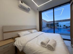 a bedroom with a bed with towels on it at Bellagio Chaleht in Al Rama