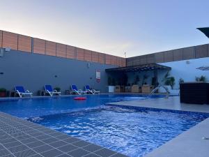 a large swimming pool with chairs in a building at Bellagio Chaleht in Al Rama