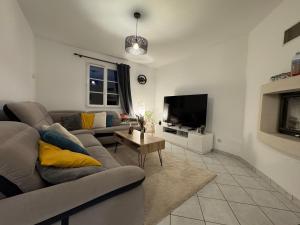 a living room with a couch and a tv at Les Lilas - 4pers - Circuit Bugatti in La Chapelle-Saint-Rémy