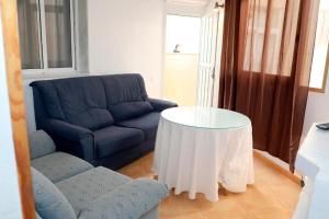 卡沃内拉斯Apartalux Luna Carboneras的客厅里有一张蓝色的沙发和一张桌子 更多49张照片