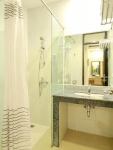 a bathroom with a sink and a shower with a shower curtain at Sweet Karina Hotel Pasteur in Bandung +40 photos