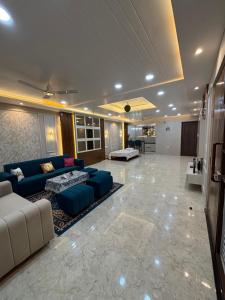 a living room with blue couches and a kitchen at DeeHa Niwas Luxe -Modern Luxury 1BHK in City Centre in Varanasi
