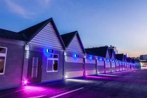 a row of buildings with purple and blue lights at TY Motel in Dayuan