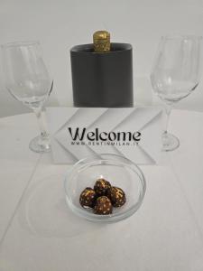 a table with two wine glasses and a plate of food at RENT IN MILAN bilocale di 40 mq con parcheggio in Milan