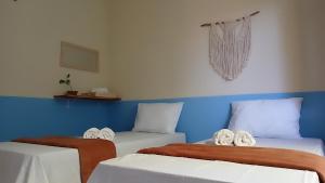 2 Betten in einem blau-weißen Zimmer in der Unterkunft Koral House - GURIÚ in Camocim