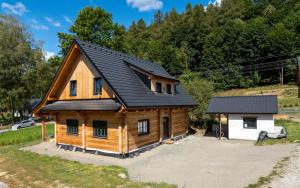 a log cabin with a black roof and a garage at Chalupa Jesenka in Sobotín