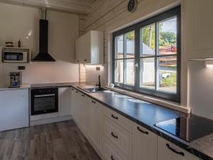 Una cocina con gabinetes blancos y una ventana grande. en Chalupa Jesenka, en Sobotín 11 fotos más