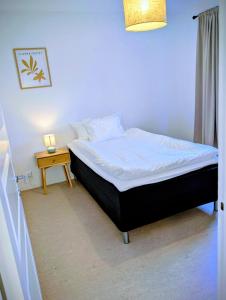 een bed in een kamer met een bijzettafel bij All you need! Fully furnished apartment in the heart of Katrineholm in Katrineholm +3 foto's
