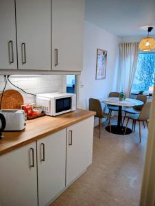 een keuken met een magnetron op een aanrecht met een tafel bij All you need! Fully furnished apartment in the heart of Katrineholm in Katrineholm