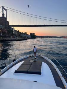 Ein Mann steht am Ende eines Bootes im Wasser in der Unterkunft Private Luxury Bosphorus Yacht 2 Continents Experience in Istanbul + 4 Fotos
