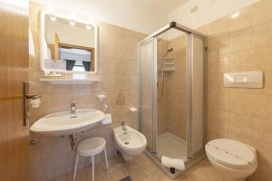 a bathroom with a sink and a shower and a toilet at Kyrr Smart Mountain Retreat in Moena +75 photos