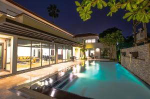a swimming pool in the backyard of a house at Villa Navin Beach Residence in Jomtien Beach
