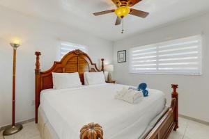 una camera con un grande letto e un ventilatore a soffitto di Coral Delight a Key Largo Altre 19 foto