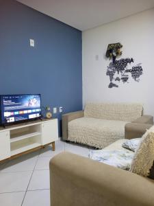 a living room with a couch and a flat screen tv at Duplex Belli a 300m do Mar in Natal
