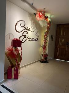 瓦哈卡市Casa Elizabeth的房间里摆满了礼物，墙上挂着一个牌子。