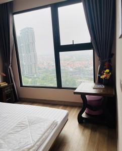 a room with a bed and a table and a large window at Nana Home in Kim Quan