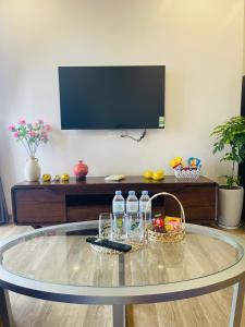 a glass table with water bottles and a basket on it at Nana Home in Kim Quan