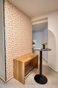 Steirerblicke City Apartments في غراتس: غرفة مع طاولة مع الزهور على الحائط +20 صورة