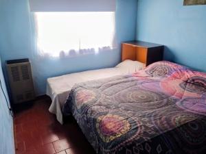 um pequeno quarto com uma cama e uma janela em Hogar "Doña Lucia" Para 3 Personas COCHERA PRIVADA GRATIS em Mar del Plata