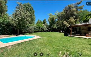 a large yard with a swimming pool and a house at Las Glicinas de Chacras in Chacras de Coria