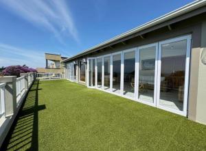 Chamane Place في ديربان: شرفة منزل مع العشب الأخضر والنوافذ