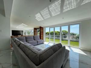 Chamane Place في ديربان: غرفة معيشة مع أريكة كبيرة وتلفزيون