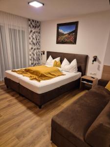 ein Schlafzimmer mit einem großen Bett und einer Couch in der Unterkunft Mountain alpine in Kappl