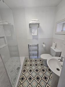 a white bathroom with a toilet and a sink at Rivelyn Hotel Bar & Restaurant in Scarborough +21 photos